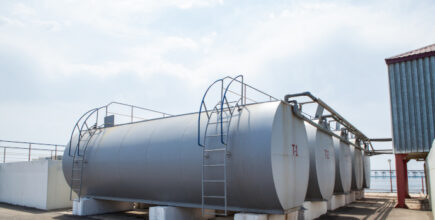 Huge oil, gas and liquid storage tanks in open air field at factory