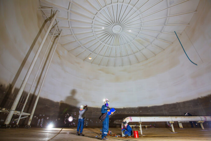 Team inspecting the inside of an industrial storage tank