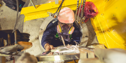 Worker wearing protective gear while working in a confined space